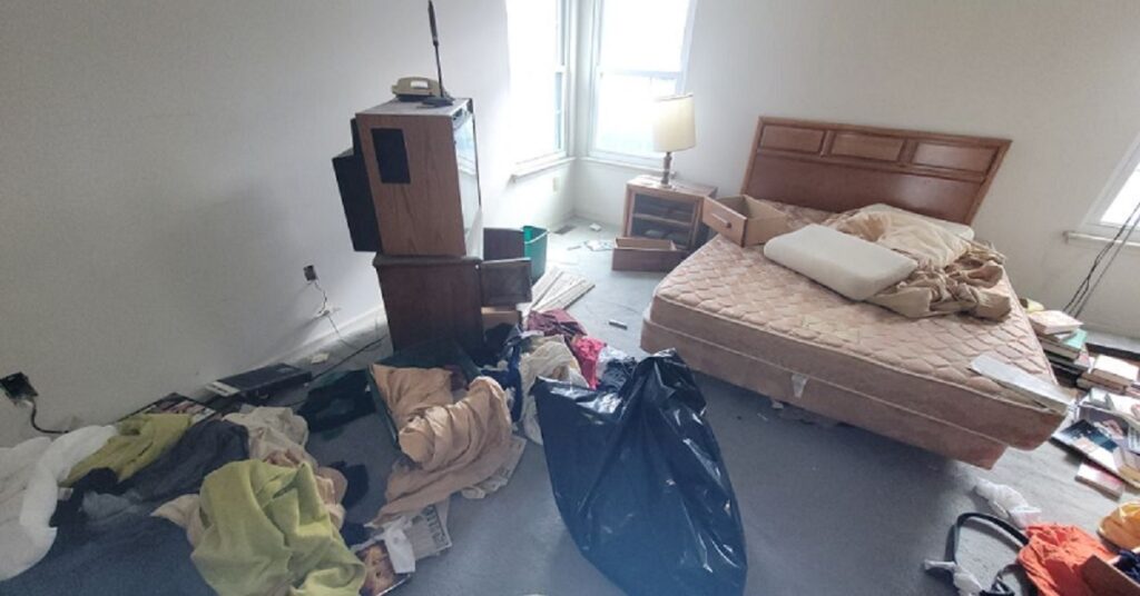 a messy room with pile of clothes and other junks including mattress that is ready to dispose