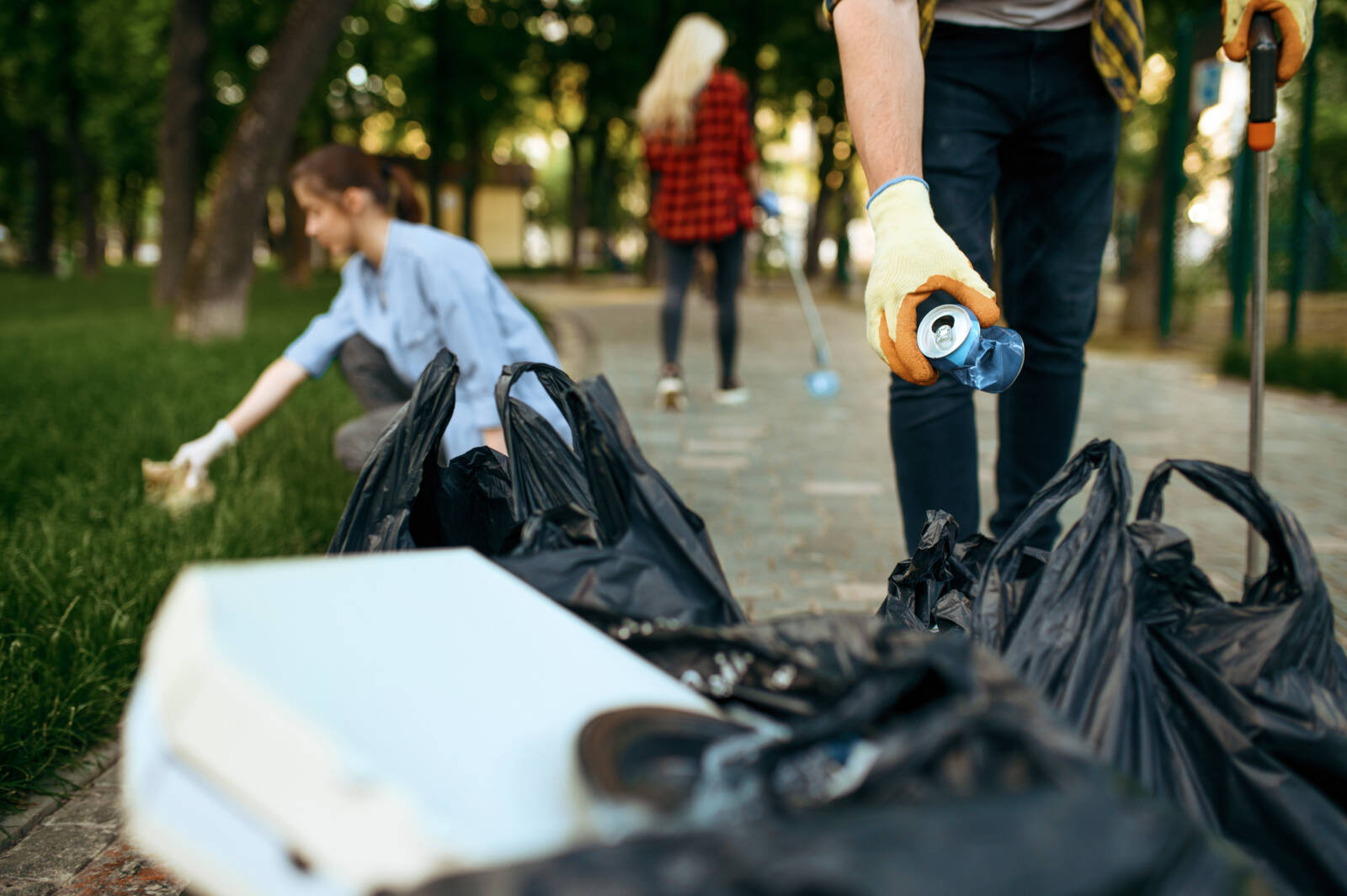 Volunteers picking trash in park, volunteering. Male person cleans forest, ecological restoration, eco lifestyle, garbage collection and recycling, ecology care, environment cleaning